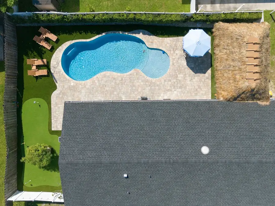 Aerial view of pool, tiki and putting green