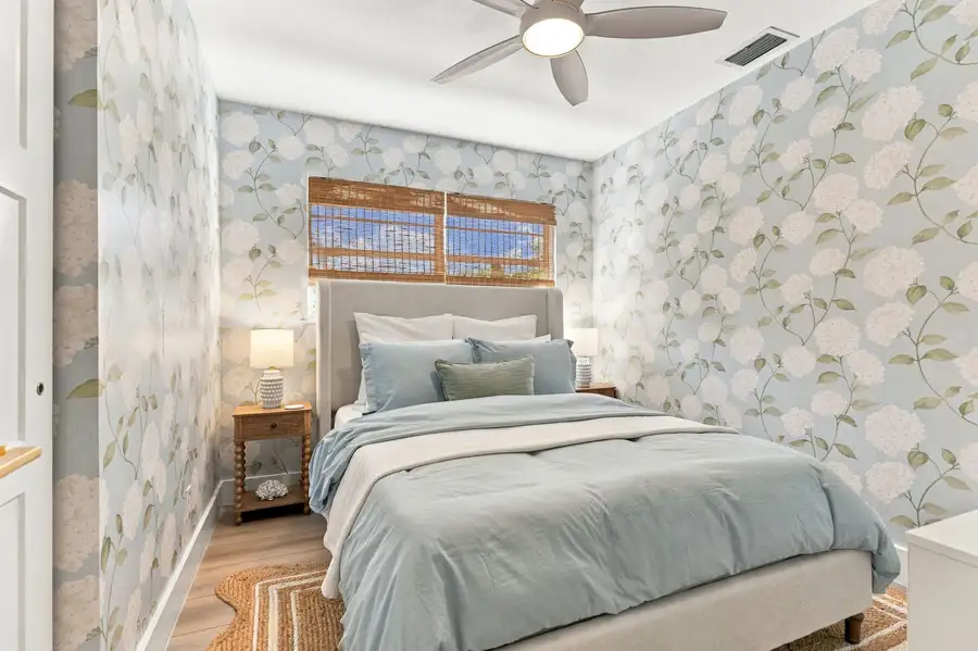 Second bedroom with queen bed and floral wallpaper